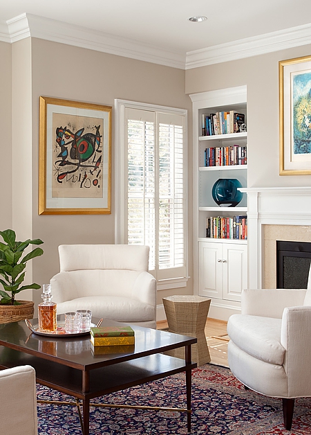 Shutters control daylight while concealed lighting brightens the fireplace.